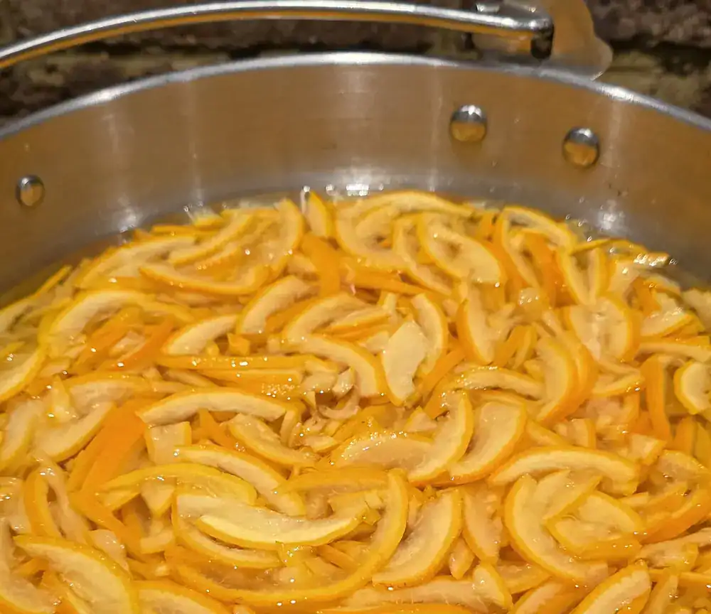The orange peel is a vivid.... err.... orange, once it's cut up, ready to be boiled in the sugared water.